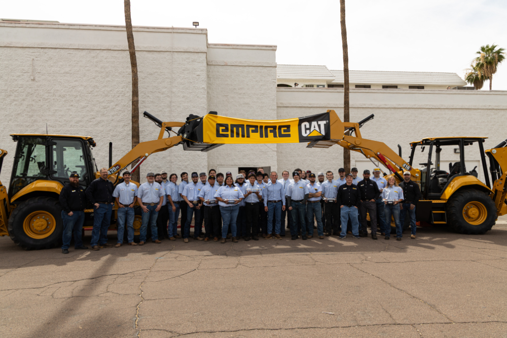 Group of graduates near Caterpillar equipment