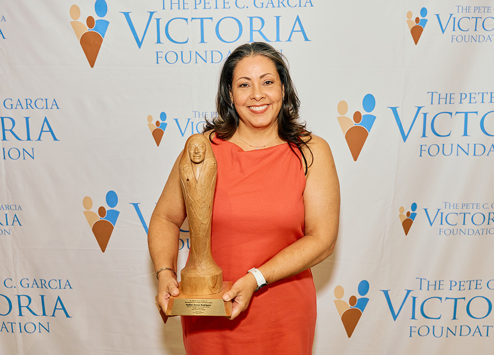 Nadine Arroyo Rodriguez holding award